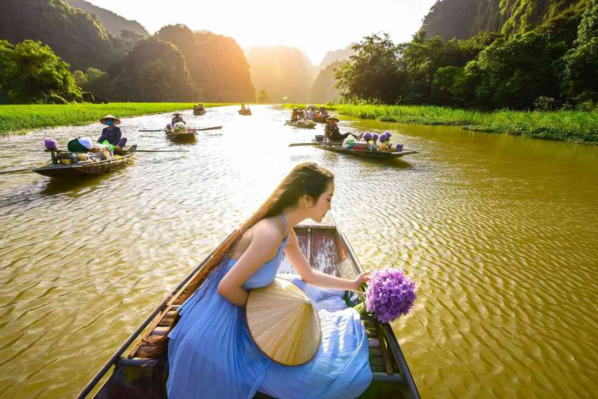 Rowboat cruising in Tam Coc with limestone karsts in the background.